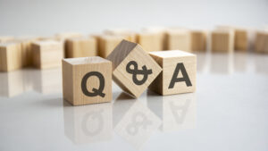 Q and A of what to ask a lawyer during a consultation - an abbreviation of wooden blocks with letters on a gray background. Reflection of the Q and A caption on the mirrored surface of the table reflective of what to ask a San Jose car accident attorney helping with San Jose car accidents