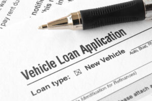 Close-up of vehicle loan application with pen