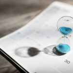 Hour glass on calendar concept for time slipping away for important appointment date, schedule and deadline for workers' compensation claim for injured workers that need medical treatment